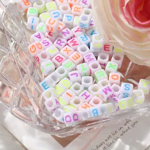 Gros plan de perles alphabet colorées pour création de bijoux DIY dans un bol en verre
