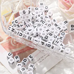 Détail macro de perles alphabet carrées blanches en acrylique pour bijoux DIY