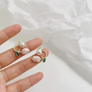 Pink tulip earrings with white pearls and gold flower stems held in hand for a fresh look