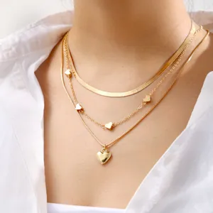 Three-layer gold necklace set featuring sleek snake chain and polished heart pendants