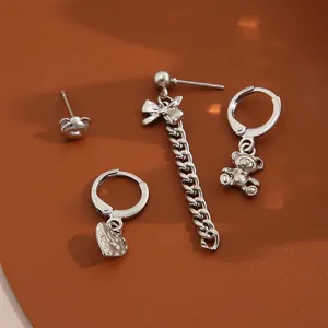 Détails d'un ensemble de 4 bijoux argentés avec breloques ours, cœur et nœud papillon