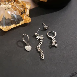 Vue détaillée du lot de 4 bijoux argentés avec pendentifs ours, cœur et nœud papillon