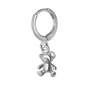Vue macro détaillée d'une boucle d'oreille avec pendentif ours en argent poli sur blanc