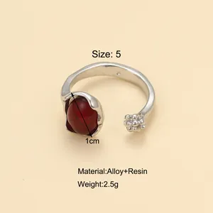 Vue détaillée d'une bague en alliage argenté avec pierre en résine rouge et perles
