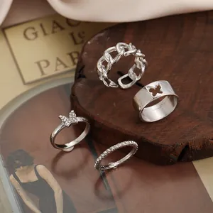 Dettaglio del set di 4 anelli a farfalla argento con strass e design a catena