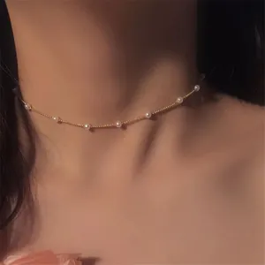 Minimalist vintage pearl choker necklace featuring gold chain and small white pearls