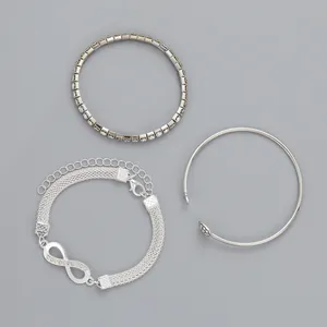 Detailset van zilveren infinity armband, tennisketting en open manchet met kristallen
