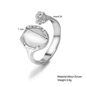 Gros plan d'une bague argentée avec disque vague de 1,1 cm et zircon sur blanc
