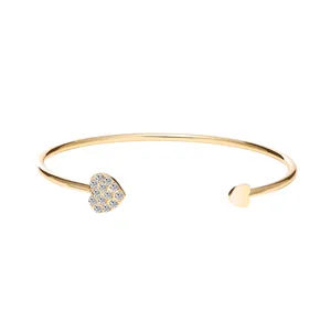 Elegante goudkleurige open armband met een sprankelend hart van kristal en een gepolijst hart