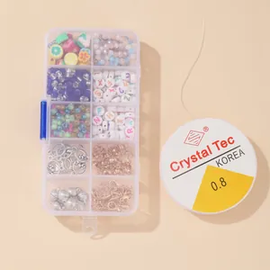 Detalle de kit de cuentas DIY bohemio con dijes de frutas y letras en caja de plástico
