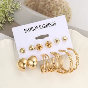 Detail eines 6-teiligen goldenen Ohrring-Sets mit Herz, Stern und gedrehten Creolen