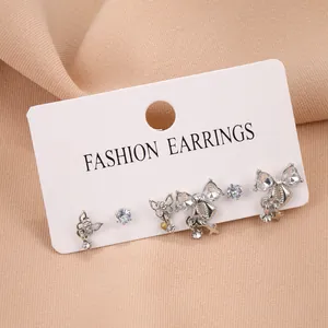 Détails des boucles d'oreilles nœud argenté et set de puces en zircon sur carte mode