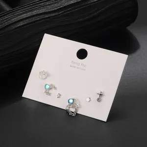 Détails d'un ensemble de boucles d'oreilles sombres avec cœurs et étoiles