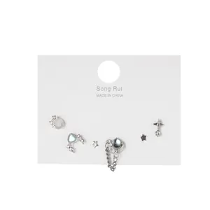 Gros plan d'un ensemble de boucles d'oreilles cœur et étoile en zircon argenté