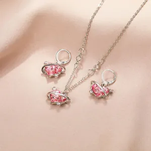 Détail de l'ensemble bijoux avec cristal coeur rose et design d'anneau de saturne argenté