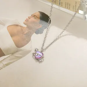 Macro shot of silver heart planet necklace with purple iridescent stone and cubic zirconia