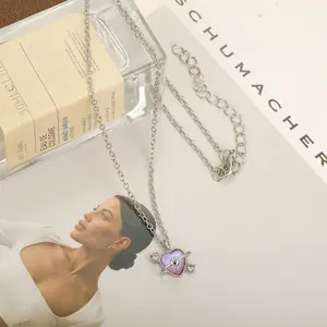 Detail of heart planet necklace with purple glitter pendant and silver chain links