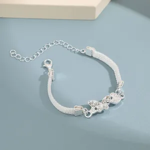 Primer plano detallado de pulsera de malla con mariposa y piedras de circonita