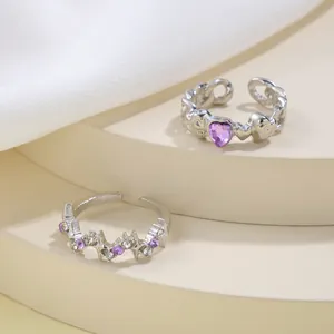 Close-up of silver open rings with purple heart stone and star-shaped zirconias