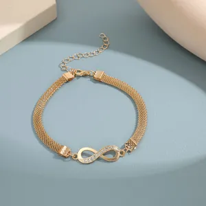 Detalle de la tobillera infinito dorada con pedrería en cadena de malla multicapa y cierre