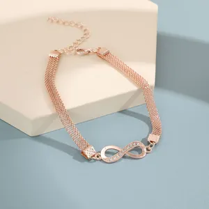 Detalle del dije de infinito en oro rosa con diamantes y cadena de malla multifila