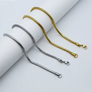 Detailed macro view of gold and silver snake bone chain necklaces with lobster clasps