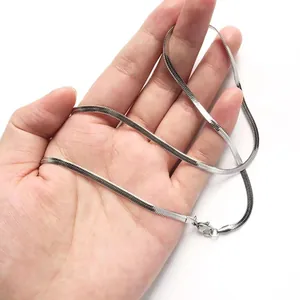 Flat silver stainless steel snake chain necklace held in hand to show metallic luster
