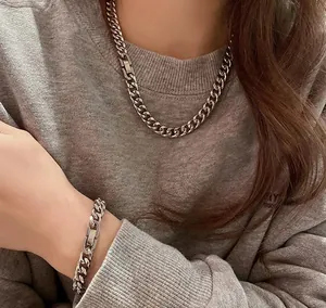 Gedetailleerd beeld van zilveren Cubaanse schakelketting en armband op model