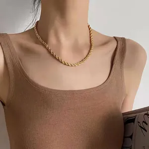 Nahaufnahme einer goldenen Twist-Seilkette am Model für einen minimalistischen Stil