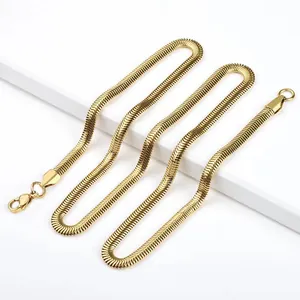 Détail d'une chaîne serpent plate dorée avec fermoir mousqueton sur un support