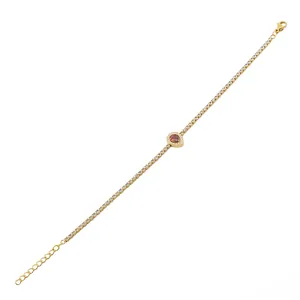 Macro-opname van gouden armband met rode peervormige steen en verstelbare sluiting