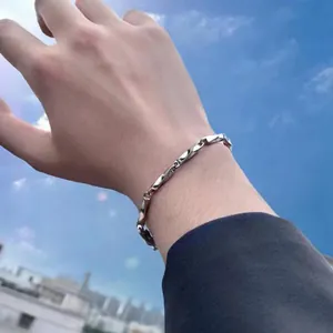 Silver Mobius twisted steel chain bracelet for women under a blue sky background