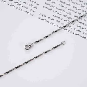 Macro-opname van zilveren titaniumstalen ruitvormige staafarmband met karabijnsluiting