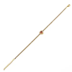 Detail van een vergulde tennisarmband met rode hartsteen en verstelbare karabijnsluiting