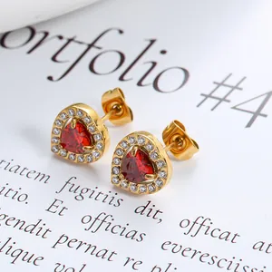 Macro shot of gold-plated heart stud earrings with red zircon and white diamond halo