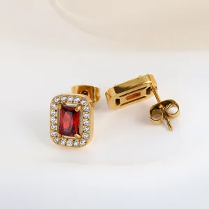 Detail view of gold earrings featuring rectangular red zircon with micro-pave crystals