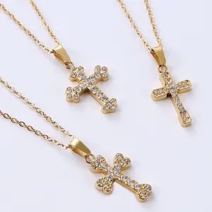 Detailed view of three gold-plated stainless steel cross necklaces with zircon inlays