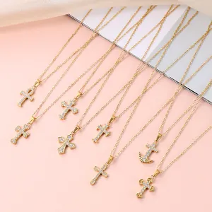 Collection of gold cross necklaces with cubic zirconia pendants on pink background