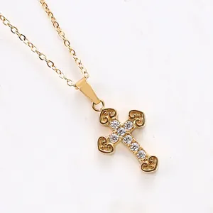 Close-up of golden cross pendant featuring heart hollows and sparkling cubic zirconia stones