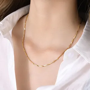Close-up of a polished gold bamboo-style stainless steel chain on a model's neck