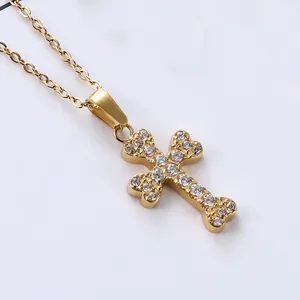 Macro shot of gold cross pendant with micro-pave cubic zirconia on delicate link chain