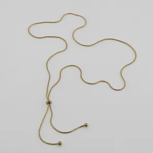 Detail of adjustable 18K gold snake chain with sliding bead and delicate metal spheres