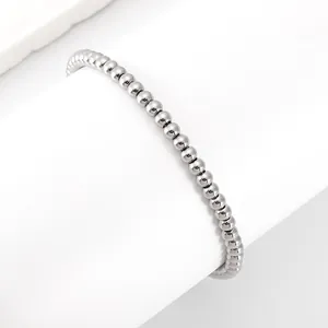 Detail view of a 4mm silver stainless steel beaded bracelet on a white geometric stand