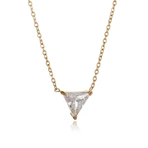 Detailed macro view of 18K gold necklace featuring a three-prong triangular zircon pendant
