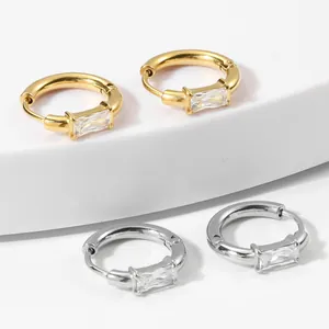 Detail of gold and silver hoop earrings with baguette cut cubic zirconia in macro view