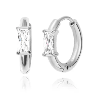 Detail of silver huggie earrings with baguette-cut zircon in a four-prong setting