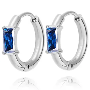 Macro view of silver hoop earrings with rectangular blue zircon in high polish