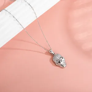 Macro shot of silver skull pendant featuring sparkling zircon micro-pave and fine link chain