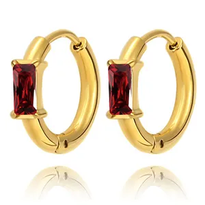 Macro detail of gold hoop earrings with rectangular red zircon and polished finish