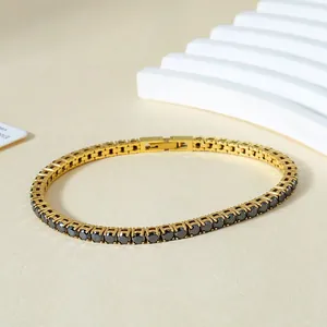 Macro detail of gold-plated tennis bracelet featuring black zircons and a secure fold-over clasp